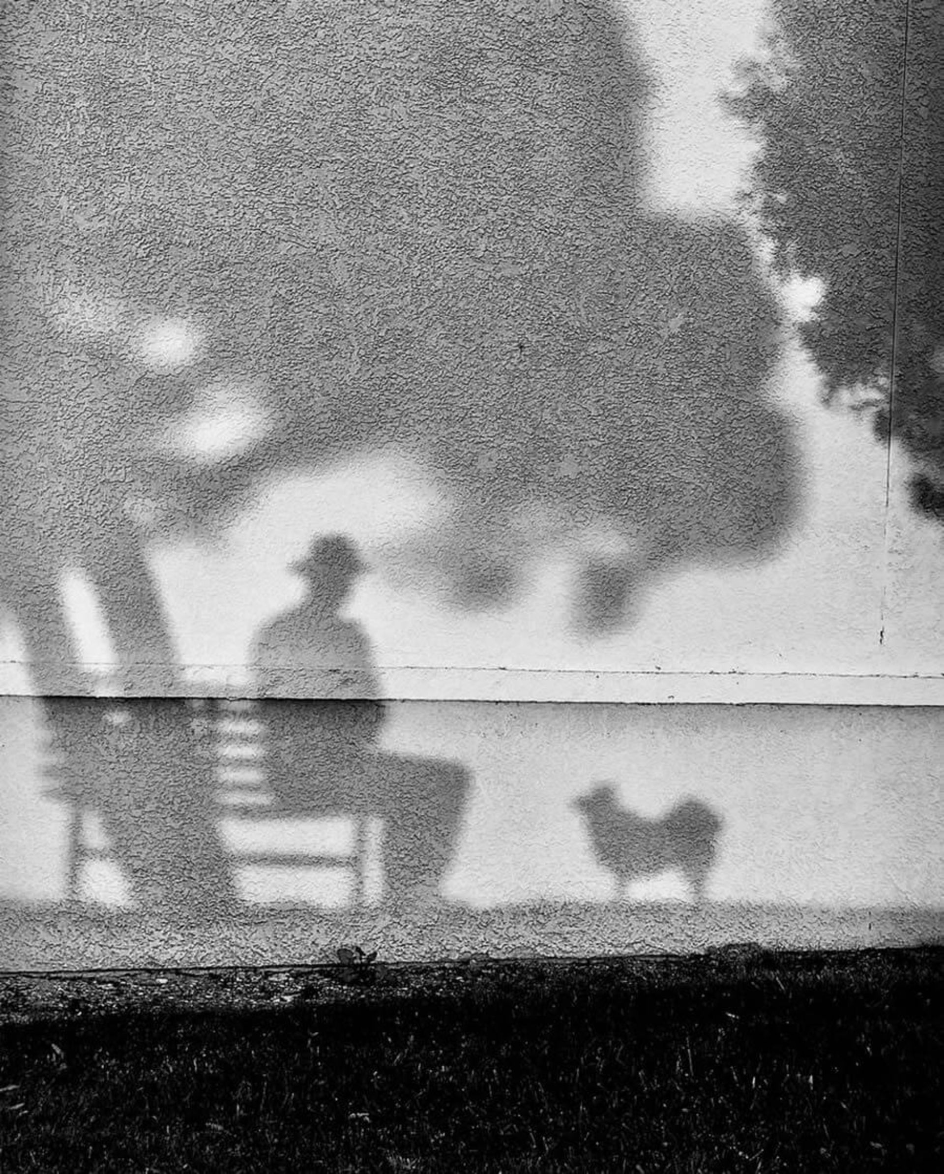 سایه مردی نشسته روی صندلی روی دیوار