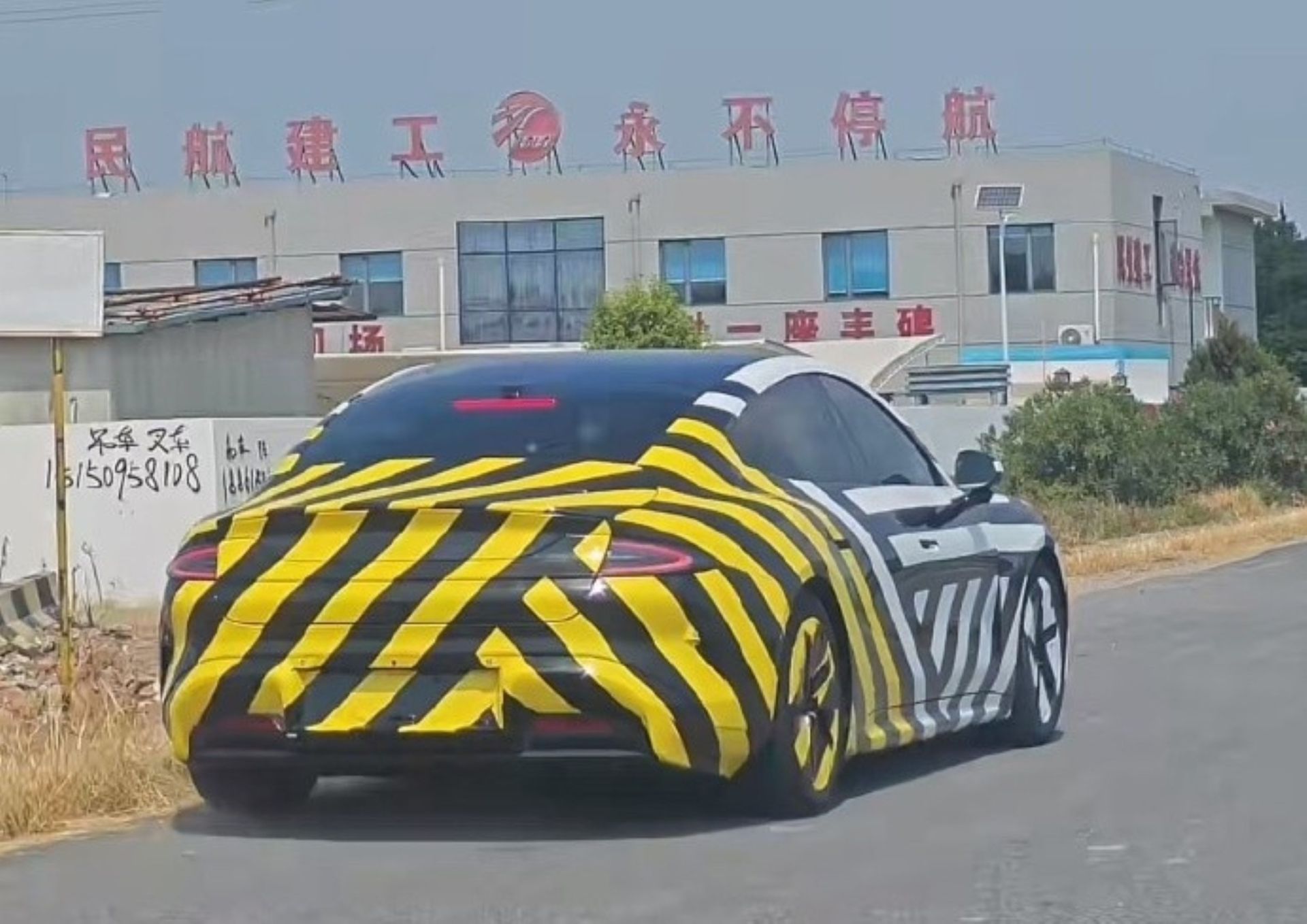 نمای سه‌چهارم عقب خودرو شیائومی SU7 L با پوشش استتاری